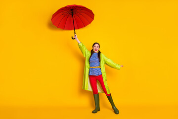 Full size photo of positive cheerful girl hold parasol air wind blow fly enjoy rainstorm walk wear...