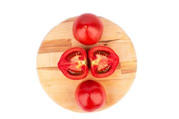 Ripe tomatoes and tomato halves on a wooden cutting board.