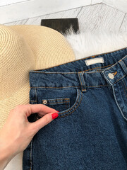 White blank tag on blue jeans on a background of white fur close-up