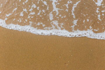 Sandy beach with waves. Empty sea and beach background with copy space