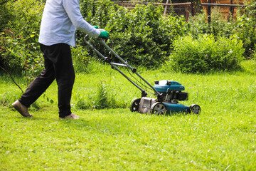 A man mows the grass on his own cottage plot