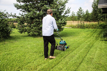 A man mows the grass on his own cottage plot
