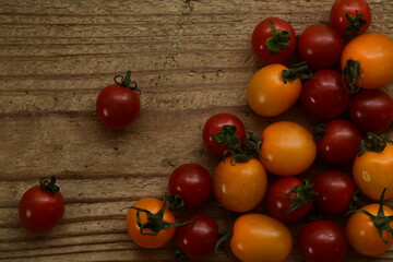 Fresh cherry tomatoes on wooden background.