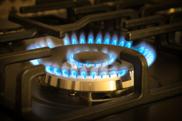 Natural gas burning by blue flames in kitchen stove. Gasification concept.
