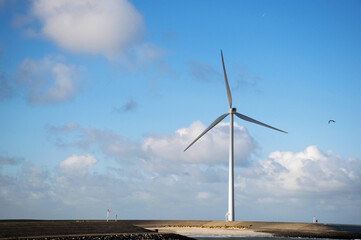 one wind turbine in landscape at the coast off the Netherlands.  Alternative green energy source, environmental technology. 