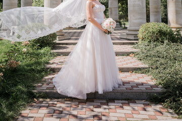 bride with a bouquet of flowers near the columns