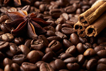 Close-up tied cinnamon sticks and anise on a heap of roasted whole coffee beans