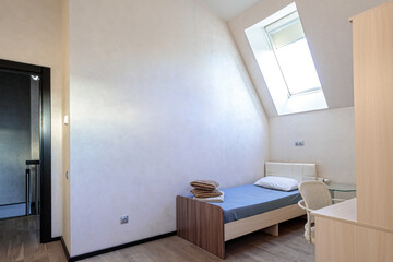 Fototapeta na wymiar The bedroom in the apartment has a single bed, minimalist design