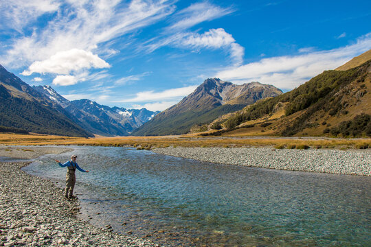 A fly fisherman casting for trout on the Ahuriri River in New Zealand © Jozef
