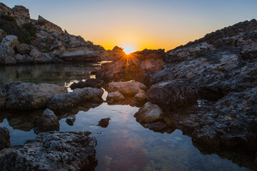 Colours of Slug's Bay at Dawn as the sea reflects the sky 