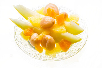 A bowl with yellow and orange fruits.