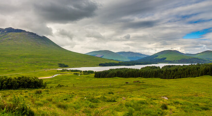 A view over Glen Tulla and with Loch Tulla in the background, surrounded by mountains and woodland