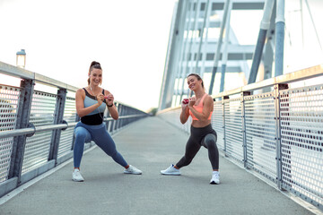 Fototapeta na wymiar Two fit body shape girl exercise outdoor at the bridge to stay in good condition