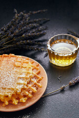 waffles in powdered sugar on a dark background, close-up
