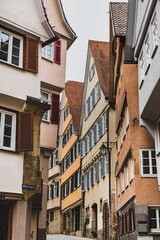 Wooden medieval building with typical pitched roof on a narrow street or alley. Historical German facade or exterior with traditional louvered shutters (jalousie) and sloping roof - Tubingen, Germany