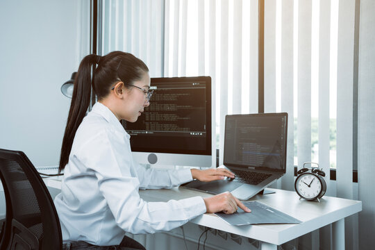 Software developers are analyzing about the code written into the program on the computer in office room.