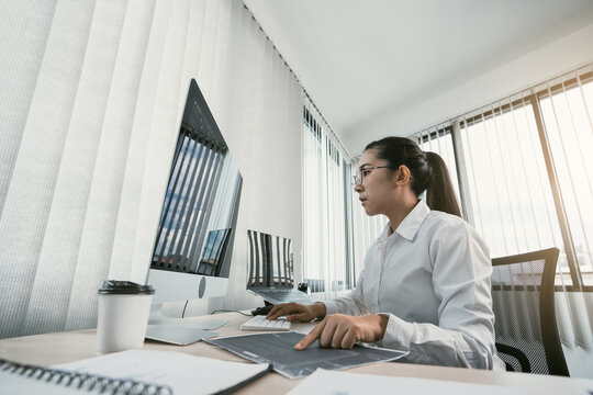 Woman asian software developers are analyzing together about the code written into the program on the computer in office room.