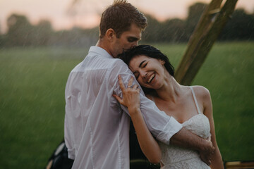 Naklejka premium Happy couple in love embraces under drops of rain.