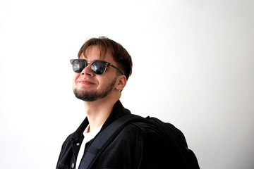 Portrait of a handsome young man with sunglasses and backpack