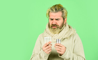 Immune system fight infections. Bacteria invades body. Virus treatment. Bearded hipster messy hairstyle. Sick man hold tablets. Virus pneumonia. Buy medicines. Virus fever. Vitamin supplements
