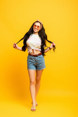 Fototapeta na wymiar smiling stylish summer brunette girl on yellow background
