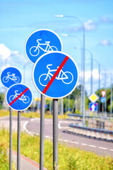 road sign for bike traffic lane on modern street in city against blue sky background. Close Up view of end of bike lane transportation symbol for bicycle rider. Information for cyclist. Vertical view