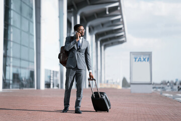 Serious Entrepreneur Talking On Cellphone Standing Near Airport, Full-Length