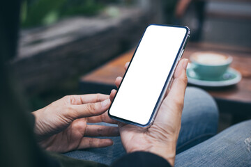 cell phone mockup image blank white screen.woman hand holding texting using mobile on desk at coffee shop.background empty space for advertise.work people contact marketing business,technology