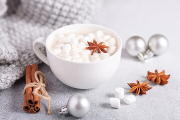 White cup with hot chocolate and marshmallow, sweater, cinnamon. Cozy christmas composition. Hygge concept Soft focus