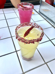 Hot Spicy Lemonade with Chili Pepper and Spices on Ceramic Square White Floor.