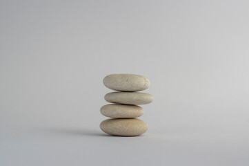 One simplicity stones cairn isolated on white background, group of four white pebbles in tower