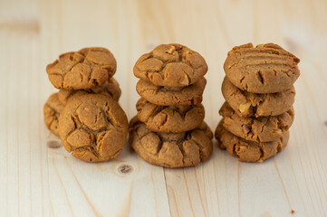 Very tasty peanut butter biscuits on bamboo light brown wooden board, golden baked healthy