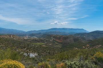 Mountainous area covered with vegetation and with cloudy sky