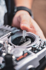 Hands holding a silver fpv drone transmitter