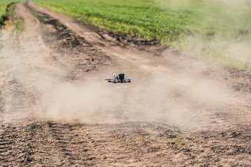 Racing drone flying over green field