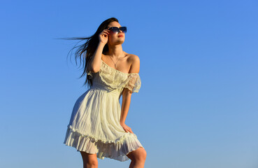 Wind of change. Fancy model in tender summer dress. Towards summer. Freedom and Harmony. Female psychology. Beautiful woman on sunny day blue sky. Summer fashion. Girl in sunglasses copy space