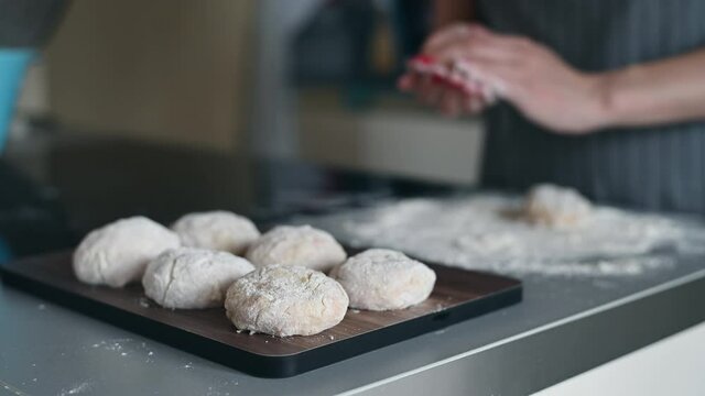 Close-up of a tasty cutlets, a female cook cooks meatballs, dipping cutlets of minced meat in flour and spreading it on a baking tray.