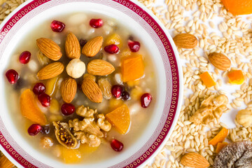 Traditional Turkish Dessert Ashure or Noah's Pudding in white bowl on ingredients of Ashure Dessert