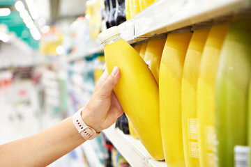Orange juice in hands buyer in shop