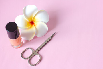 Obraz na płótnie Canvas Manicure scissors nail polish and flower on pink background, manicure pedicure hygiene and body care, selective focus