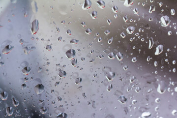 A small raindrop rests on the glass after rain.