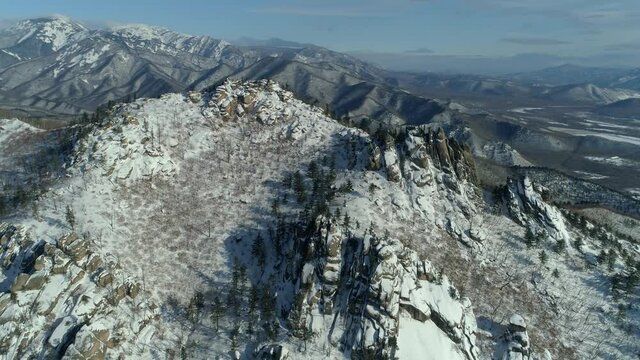Aerial epic winter nature mountains network landscape Vladivostok Far East. Cinematic snow cowered North epic hills, ancient rocky megaliths on peaks. Travel best scenery. Expanse, freedom. Sunny day