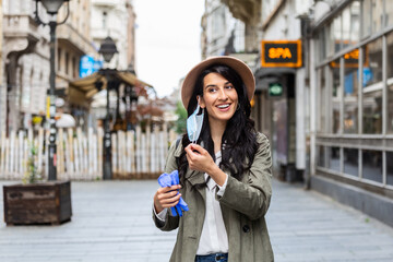 Obraz premium Coronavirus is over we won concept. Woman holding mask. We won sign outdoor in the sunshine freedom. We are safe. Coronavirus ended. We won. No more quarantine. Breathe deep. Take off the mask. Cure.