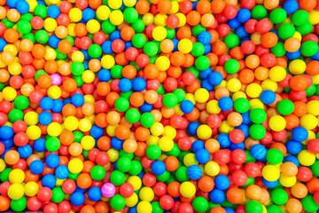 Fototapeta na wymiar Multi-colored balls in a children's attraction. Background texture of colourful foam balls