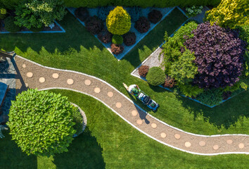 Gardener with Grass Mower Trimming Backyard Lawn Aerial View - obrazy, fototapety, plakaty