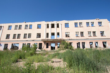 Abandoned ruined buildings on a vacant lot in a small semi-deserted city.