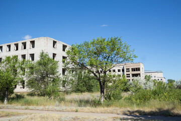 Abandoned ruined buildings on a vacant lot in a small semi-deserted city.
