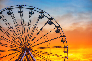 Ferris Wheel with sunset sky and clouds