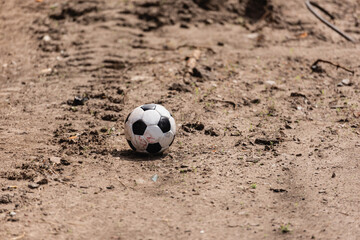 Dirty soccer ball on road on urban street