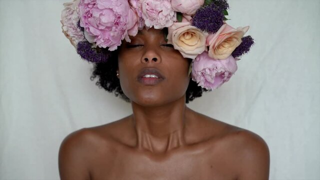 Black woman with flower crown blows kiss